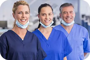 Three dentists smiling in group photo at their office.